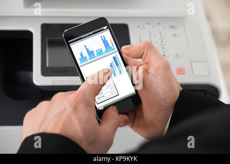 Geschäftsmann mit Print Befehl auf Smart Phone Stockfoto