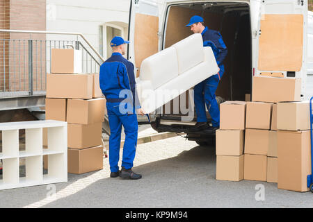 Movers Entladen Sofa vom Lkw Stockfoto