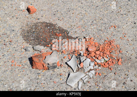 Die gebrochenen Ziegel und Schiefer auf Asphalt Stockfoto