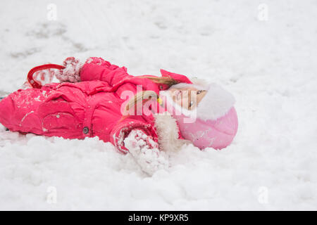 Die Mädchen liefen über die Hügel und liegt in snowdrift Stockfoto