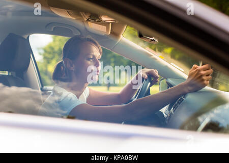 Junge Frau, die ihr Auto, auf dem Weg von der Arbeit nach Hause Stockfoto