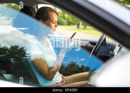 Junge Frau, die ihr Auto, auf dem Weg von der Arbeit nach Hause Stockfoto