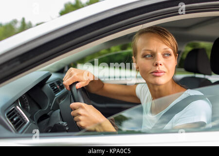 Junge Frau, die ihr Auto, auf dem Weg von der Arbeit nach Hause Stockfoto