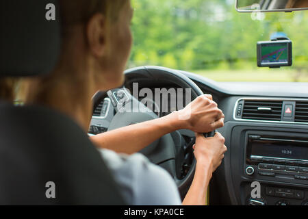 Junge Frau, die ihr Auto, auf dem Weg von der Arbeit nach Hause Stockfoto