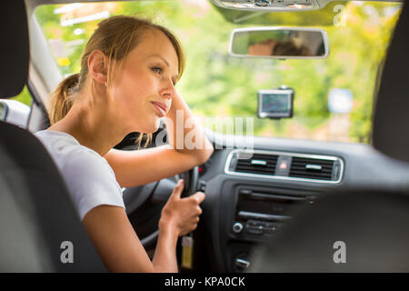 Junge Frau, die ihr Auto, auf dem Weg von der Arbeit nach Hause Stockfoto