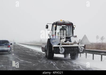 Kleine Schneepflug mit Bürsten Fahrten auf der Strecke und Schneeräumung Stockfoto