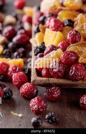 Mischung aus getrockneten Früchten und Beeren auf einem Holztisch. Stockfoto