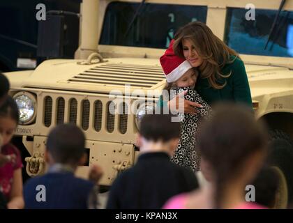 Washington, Vereinigte Staaten von Amerika. 13 Dez, 2017. First Lady der USA Melania Trump Umarmungen ein Kind während der jährlichen Marine Corps Stiftung Spielwaren für Tots bei Joint Base Anacostia-Bolling Dezember 13, 2017 in Washington, DC. Die erste Dame folgte die langjährige Tradition der anderen Tannen Damen in helfenden Kindern Karten, sortiert Spielzeug und das Charity Event Credit: Planetpix/Alamy Leben Nachrichten Ehre Stockfoto