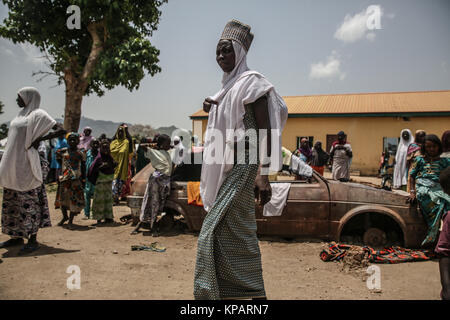 Borno State, Nigeria. 27 Juni, 2017. Eine Frau geht vorbei an einem Ausgebrannten Auto in ein Lager für die Vertriebenen. Credit: Sally Hayden/SOPA/ZUMA Draht/Alamy leben Nachrichten Stockfoto