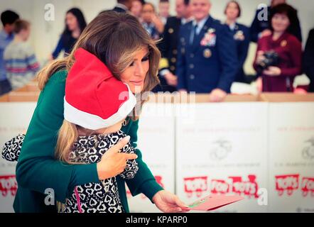 Washington, Vereinigte Staaten von Amerika. 14 Dez, 2017. First Lady der USA Melania Trump Umarmungen ein junges Mädchen während der jährlichen Marine Corps Stiftung Spielwaren für Tots bei Joint Base Anacostia-Bolling Dezember 13, 2017 in Washington, DC. Die erste Dame folgte die langjährige Tradition der anderen Tannen Damen in helfenden Kindern Karten, sortiert Spielzeug, und der Nächstenliebe, die Veranstaltung zu Ehren. Credit: Planetpix/Alamy leben Nachrichten Stockfoto