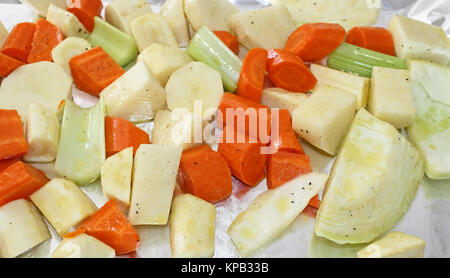 Schneiden, Kartoffeln, Karotten, Pastinaken, Sellerie und Kohl mit Salz und Pfeffer gewürzt und mit Öl beträufelt Bratfertig Stockfoto