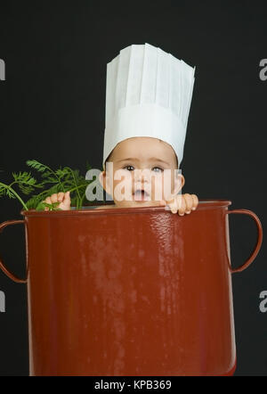 Model Release, Kleinkind Mit Kochhaube Im Kochtopf - kleines Kind mit Küchenchefs Kappe im Kochtopf Stockfoto