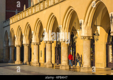 Kolonnade arcade Europa, zwei junge Frauen durch einen Säulengang der Renaissance Tuchhallen (Sukiennice) auf dem Marktplatz in Krakau, Polen. Stockfoto