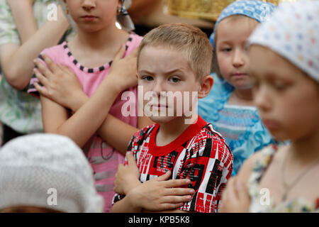 Belarus, Gomel Stadt, St. Nikolaus Kloster, einer religiösen Orthodoxen Ferienwohnung "Palm Sonntag 19.06.2016 Jahr. Der Junge vor einem Ritus der Gemeinschaft. Kind Stockfoto