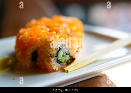 Closeup Bild von Restaurant Platte mit orange Sushi rollen, Ingwer und Essstäbchen Stockfoto