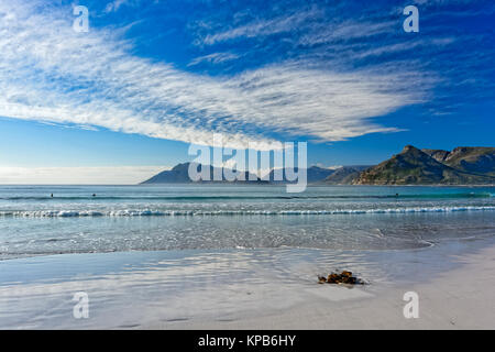 Farbe im Freien malerischen Panorama einer Strand in Hout Bay in der Nähe von Kapstadt, Südafrika mit Bergen, blauen Meer, Himmel mit ein paar helle Wolken Stockfoto