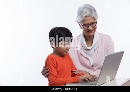 Großmutter und Enkel zusammen sitzen mit Laptop Stockfoto