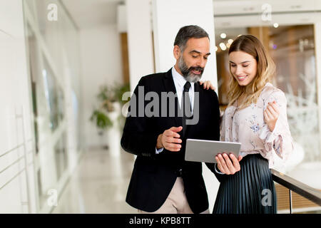 Portrait von mittlerem Alter Geschäftsmann und junge geschäftsfrau mit Tablette offfice Stockfoto