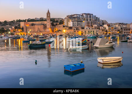 Fischer und Passagierschiffe in Marsaskala Bay in Malta am frühen Abend Stockfoto