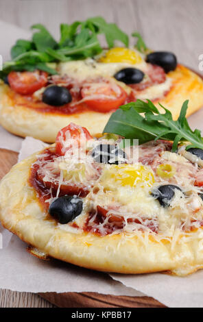 Mini Pizza mit Würstchen und Ei und Rucola für Frühstück Stockfoto