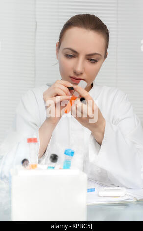 Porträt eines jungen Wissenschaftlers, Tech oder Diplomand Kennzeichnung Rohr für das Experiment. Flache DOF, auf dem Gesicht konzentrieren Stockfoto