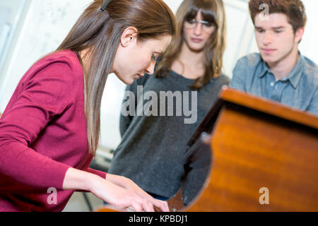 Lächelnde junge weibliche Kunden Auswahl Synthesizer in Store Stockfoto