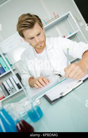 Hübscher junger Wissenschaftler in weiße Uniform Forschung im Labor Stockfoto