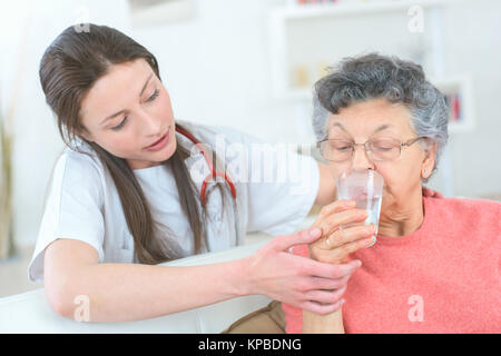 Die ältere Dame ein Glas Wasser Stockfoto