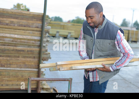 Mann, der Holz im Materiallager Stockfoto