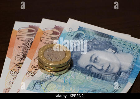 Die Britische Pfund Sterling neue Serie G Banknoten und Münzen. GBP 28 besteht aus zwei 10-lbs-Notes, ein 5-pound Note und drei £ 1 Münzen. Stockfoto