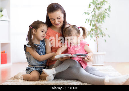 Hübsche Mutter Lesung buchen Sie ihren Töchtern Stockfoto