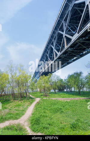 Brücke über grasbewachsene Landschaft mit Skyline. Stockfoto