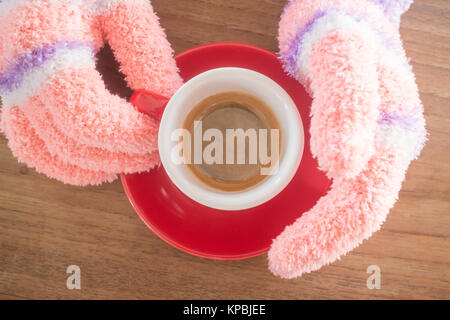 Behandschuhten Hände, die Tasse Kaffee Stockfoto