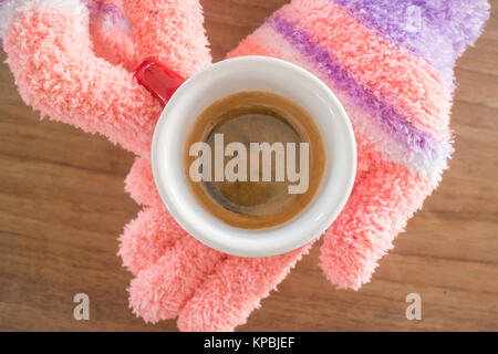 Behandschuhten Hände, die Tasse Kaffee Stockfoto