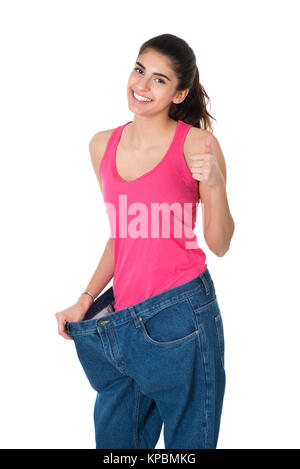 Frau Gestik Daumen hoch und zeigt Ihre alte Jeans Stockfoto