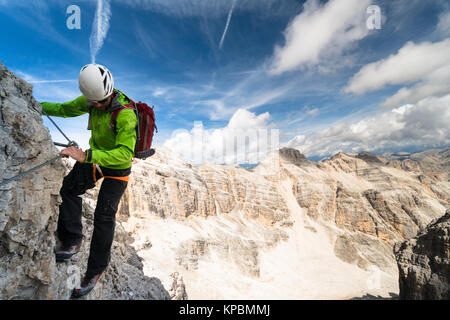 Männliche Bergführer auf einem steil und ausgesetzt Klettersteige in den Dolomiten in Südtirol in Italien Stockfoto