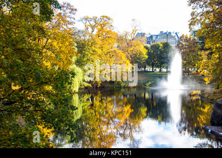 Brunnen und Regenbogen in Riga Kanal, fließt durch die Bastion Park Herbst Hintergrund mit farbigen Blätter (Bastejkalns). Lettland Herbst Stockfoto