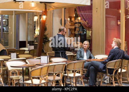 Mann und Frau in einem Pariser Café sitzen Stockfoto