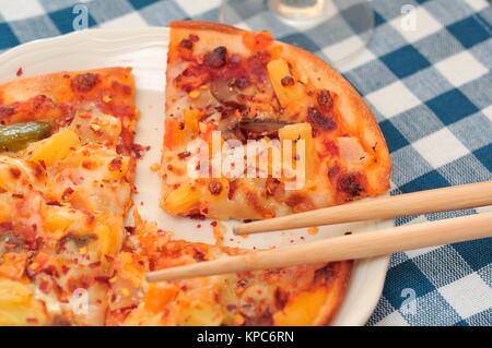 Frisch gebackene Pizza Käse in Scheiben geschnitten und serviert. Stockfoto