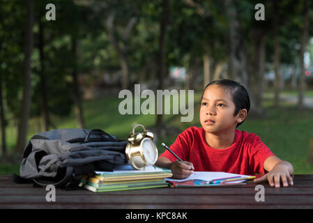 Jungen asiatischen Jungen studieren im Park, während der leere Raum suchen. Lernen Konzept Stockfoto