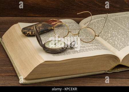 Altes Buch mit Brille und Taschenuhr Stockfoto