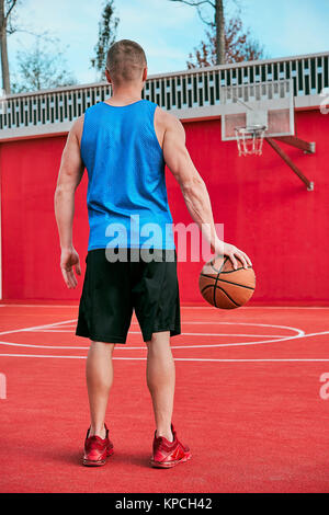 Mann auf der Straße spielt Basketball Stockfoto