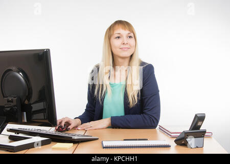 Schöne Mädchen, Sekretärin an einem Computer arbeiten sah Besucher Stockfoto