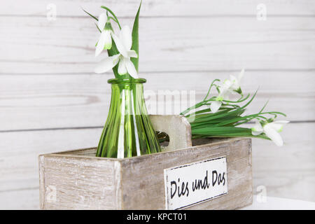 Lilie des Tages in grüner Vase und Holzkiste vor einer Holzwand im Shabby Chic Stockfoto