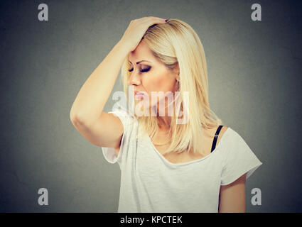 Junge Frau mit der Hand auf dem Kopf suchen forgetfully und versucht, an etwas zu erinnern. Stockfoto