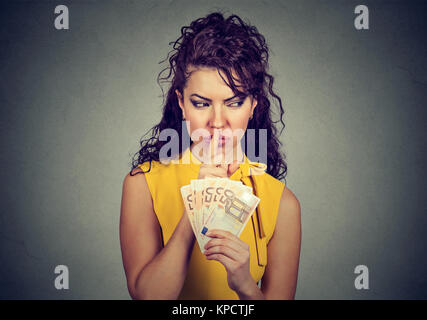 Frau mit Haufen von Euro und bittet um Ruhe beim Üben von Korruption. Stockfoto