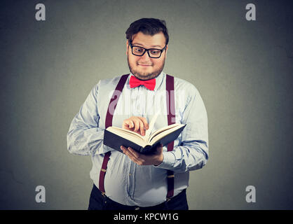 Inhalt Mann in Brillen lesen interessante Buch suchen etwas erstaunt. Stockfoto
