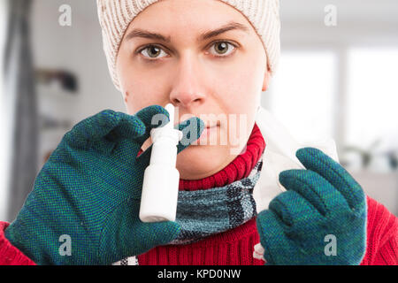 Kalte Frau mit Nasenspray zu Hause wie Grippe oder Influenza Konzept und halten ein Gewebe Stockfoto