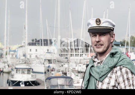 Porträt eines Mannes in ein Matrose Cap auf dem Deck eines Segelbootes Stockfoto