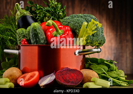 Zusammensetzung mit Topf und rohem Gemüse Stockfoto